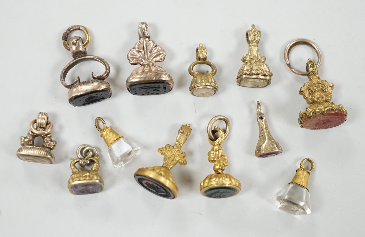 A collection of twelve small 19th century mainly yellow metal fob seals, with assorted matrices including bloodstone, amethyst, citrine and carnelian, largest 22mm.